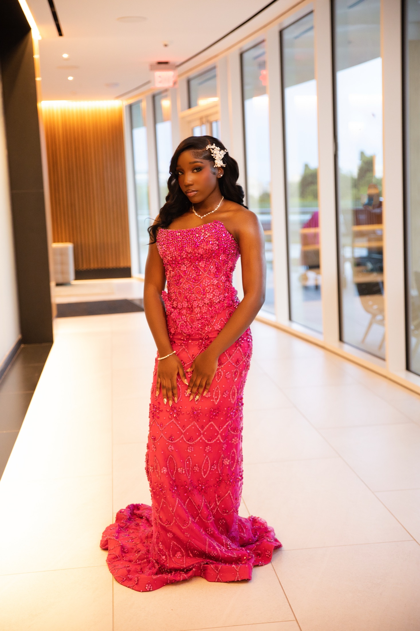 Formal portrait in a pink gown inside a modern hallway