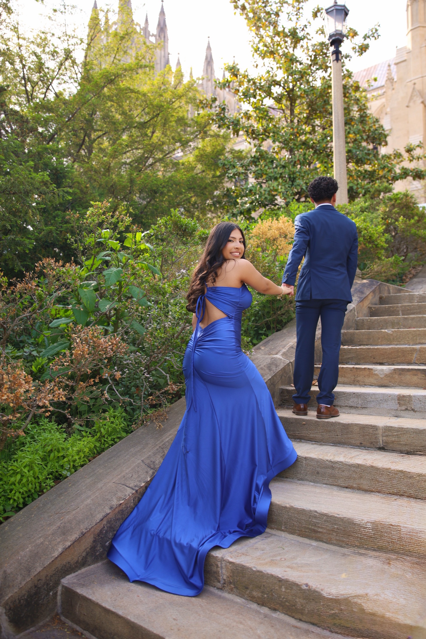 Couple walking up cathedral steps in formalwear