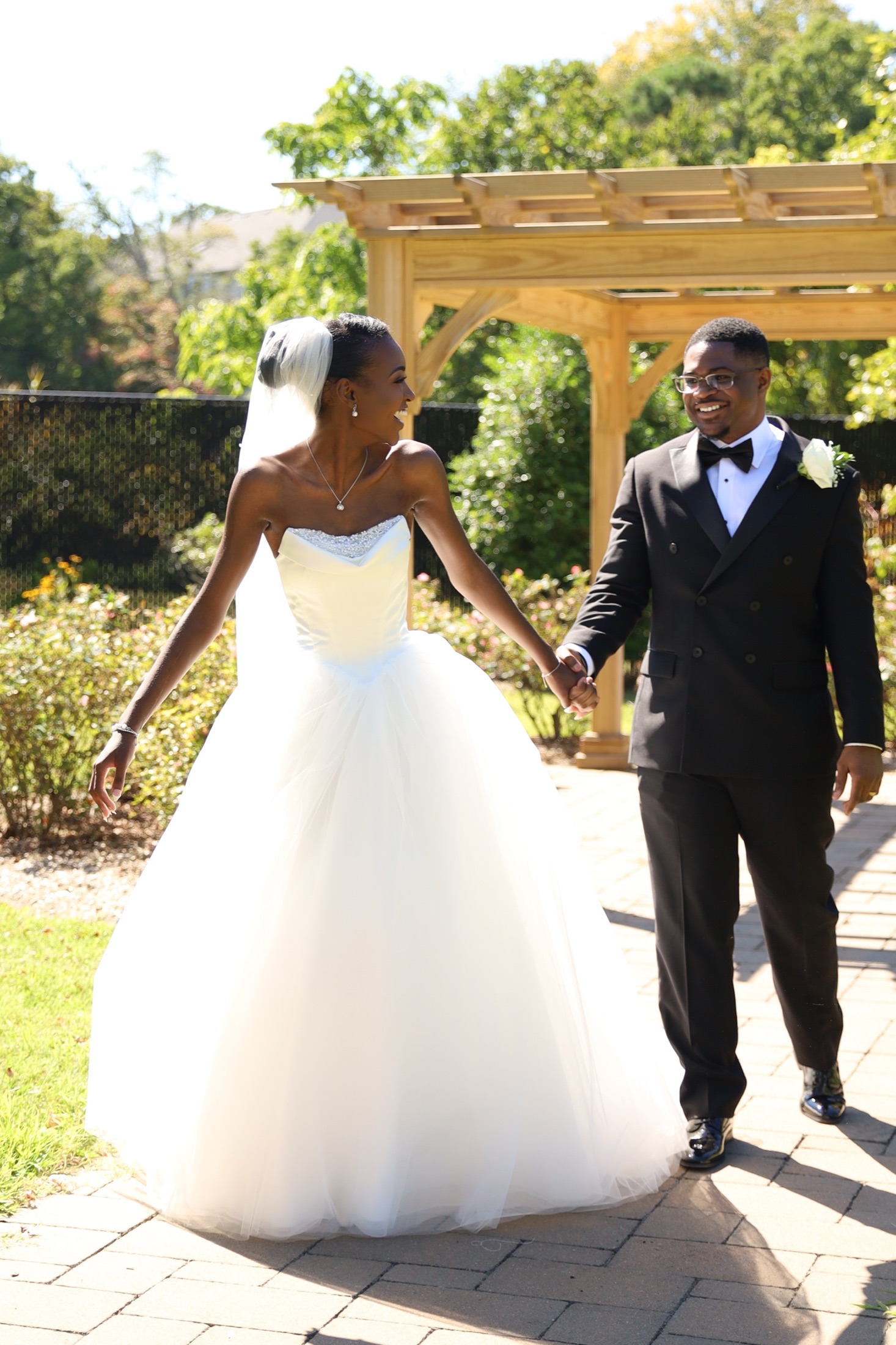 Bride and groom walking outside in bright wedding light